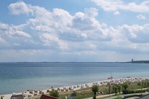 A beach with rows of sun loungers, a clear sky, and a calm sea. - Strandperle Apartment 402 - Strandperle (Scharbeutz)