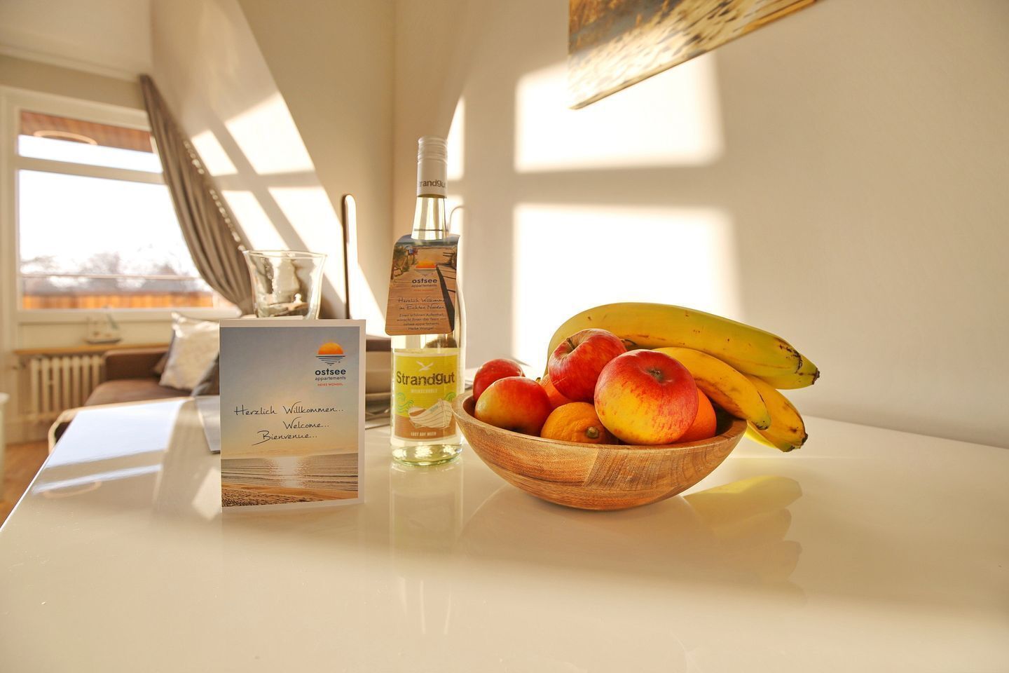 Een tafel met een fruitschaal, een fles en een welkomstkaart.