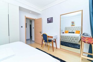 Ein Hotelzimmer mit einem Bett, einem Schreibtisch, einem Stuhl, einem Spiegel und einem Kleiderschrank.
