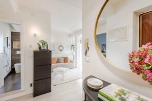 En moderne stue med sofa, sofabord og et dekorativt spejl.