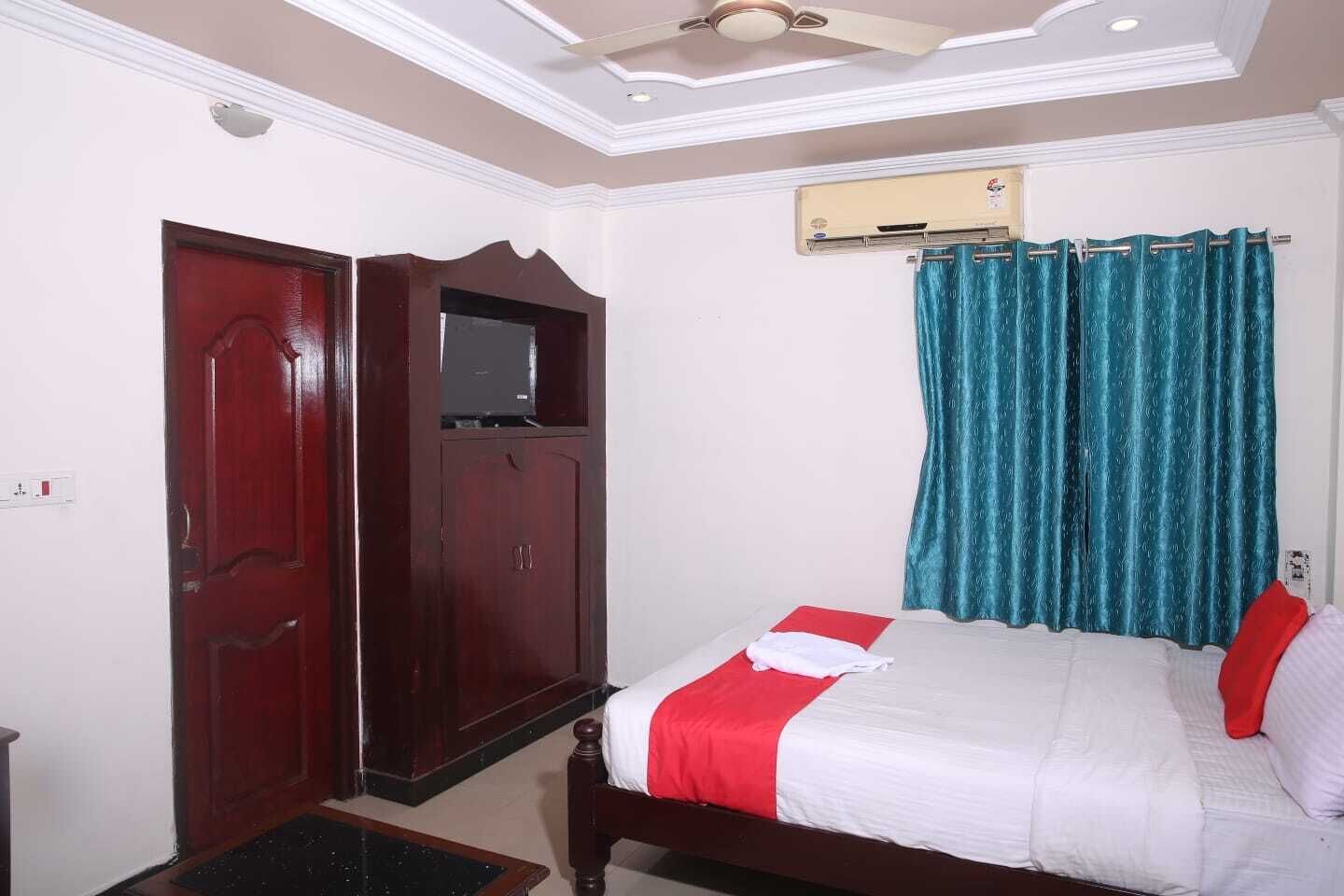 Un dormitorio con cama, armario, ventilador de techo y ventana con cortinas.