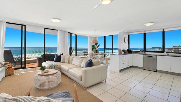 A modern living room with a sofa, coffee table, and a view of the ocean. - Absolute Beachfront on Albatross - SeaView 3 bed (Mermaid Beach)