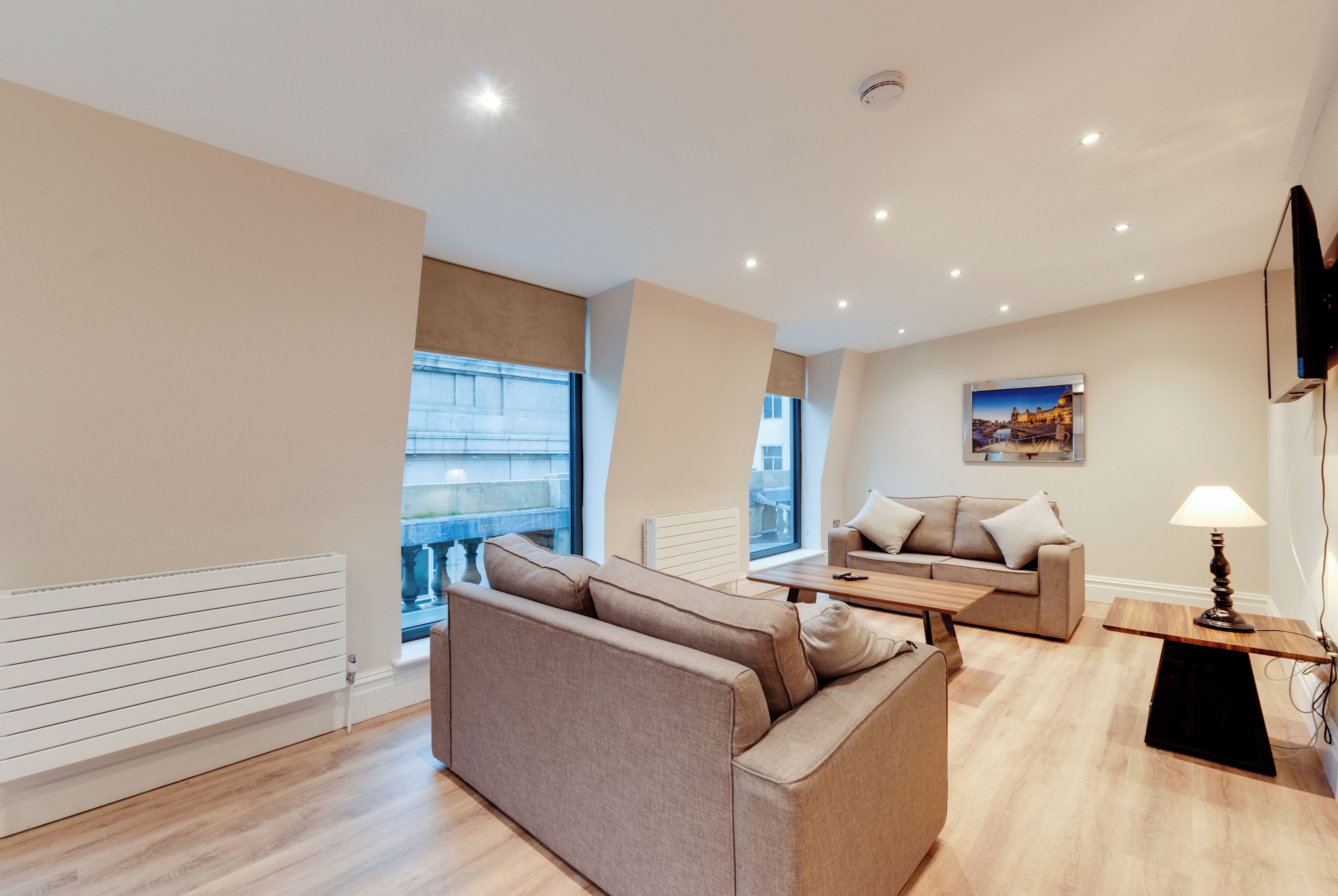 A modern living room with a sofa, a small table, and a lamp.