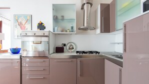 A modern kitchen with stainless steel appliances, a built-in oven, and a gas stove. - Panoramic Apartment Fori Imperiali (Rome)