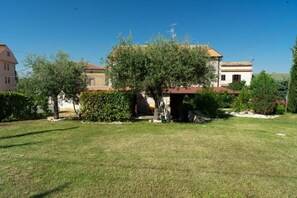 A residential property with a well-maintained lawn, a large tree in the front yard, and a house with a tiled roof. - BED & BREAKFAST MAFI (Orsogna)