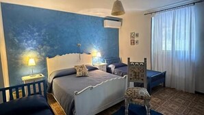 A bedroom with a bed, bedside tables, a chair, a patterned rug, and a window with curtains. - BED & BREAKFAST MAFI (Orsogna)