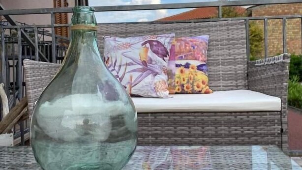 A glass table with a green bottle in an outdoor setting. - BED & BREAKFAST MAFI (Orsogna)