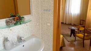 A bathroom with a white sink, mirror, and decorative plant shelf. - BED & BREAKFAST MAFI (Orsogna)