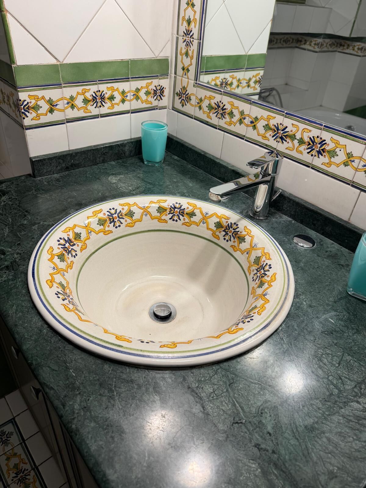 Un baño con un lavabo redondo, un espejo y un grifo.