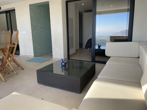 A modern living room with a glass coffee table, white sofa, and a view of the city through large windows. - Ref. Ali12 Modern villa with private pool and sea view (Rosas / Roses)