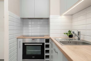 Eine moderne Küche mit Backofen, Spüle und einer Holzarbeitsplatte.