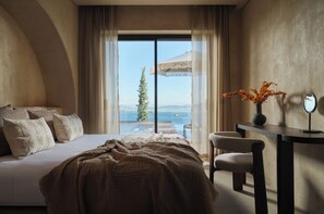 A bedroom with a large bed, a desk, a chair, and a view of the sea through a window. - Galithea Villa, Heated Pool & Marathonisi SeaViews (MR9X+3X4 Laganas, Greece)