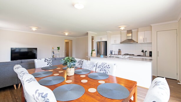A modern kitchen with white cabinets, a stainless steel refrigerator, and a built-in oven.
