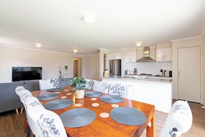 A modern kitchen with white cabinets, a stainless steel refrigerator, and a built-in oven. - Family Home for a Fiesta (Elizabeth Downs)
