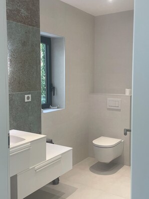 Regadera, secadora de cabello, toallas, papel de baño 