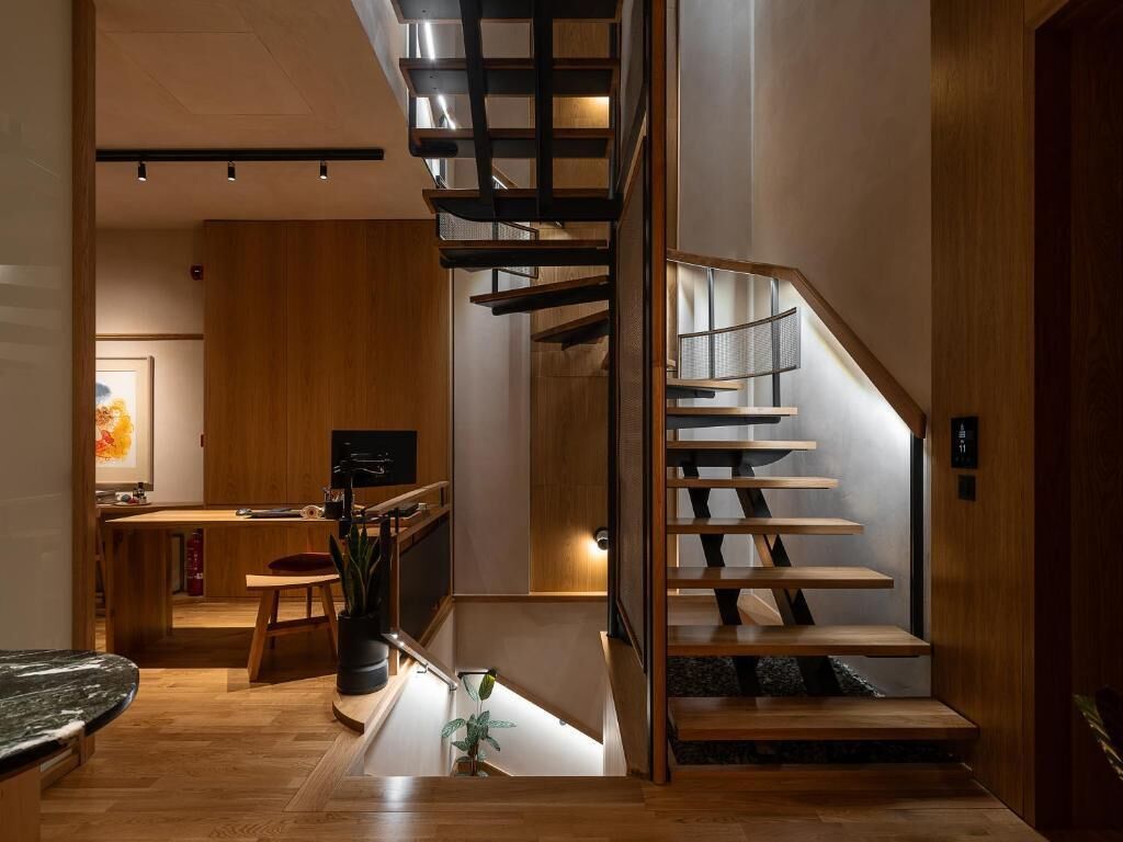 Ein modernes Interieur mit einer Holztreppe, einer Küchenzeile und einem Essbereich.