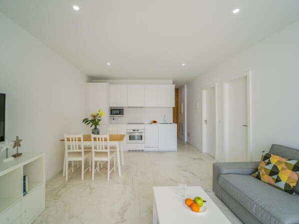 Eine moderne Wohnung mit Küche, Essbereich und Wohnzimmer.