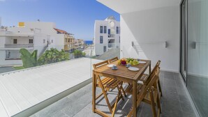 A balcony with a wooden table set for two, overlooking a residential area with white buildings and a clear blue sky. - CHL Naos del Mar, lovely place pool beach (Los Llanos de Aridane)