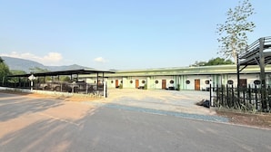 A building with a covered outdoor area, multiple doors, and a fenced perimeter.