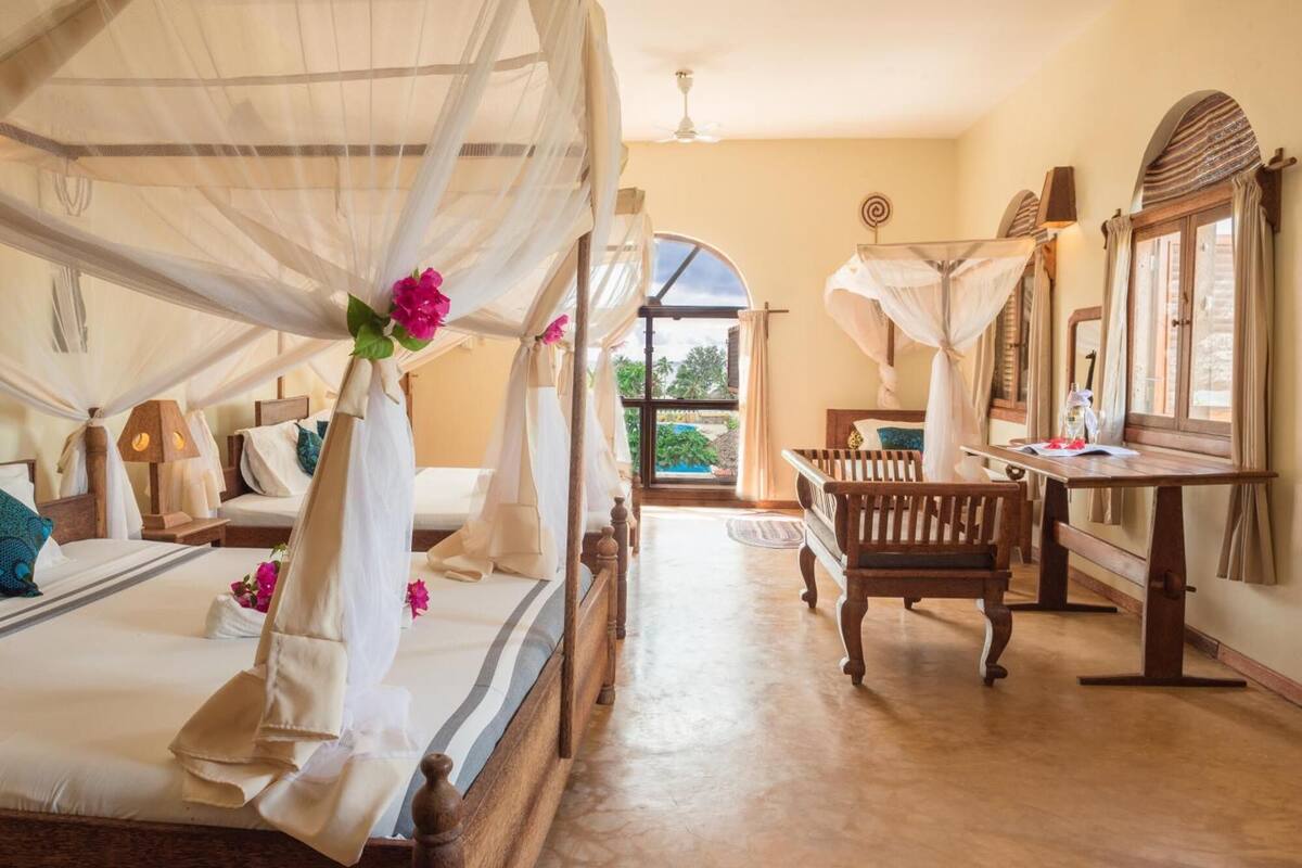 Una habitación con cama, escritorio y vistas al exterior.
