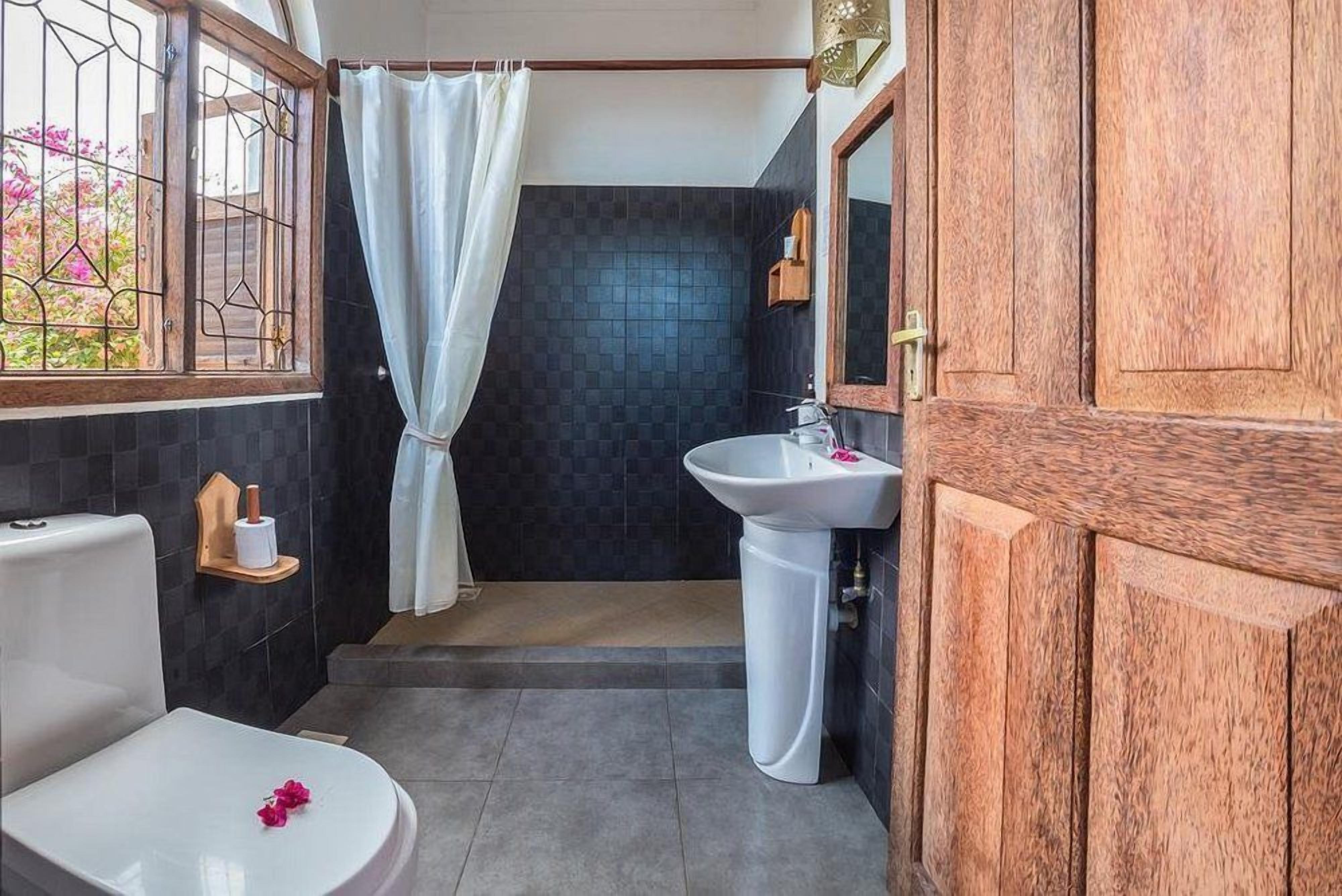 Un baño con inodoro, lavabo y zona de ducha.