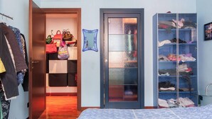 A bedroom with a wardrobe, a mirrored closet door, and a shelving unit. - Elegant and quiet little gem in downtown milan (M4 DATEO) (Milano)
