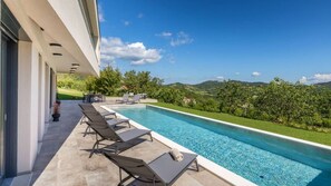 A swimming pool with lounge chairs, a covered patio, and a view of the countryside. - Butoniga Hills by Villas Guide (Pazin)