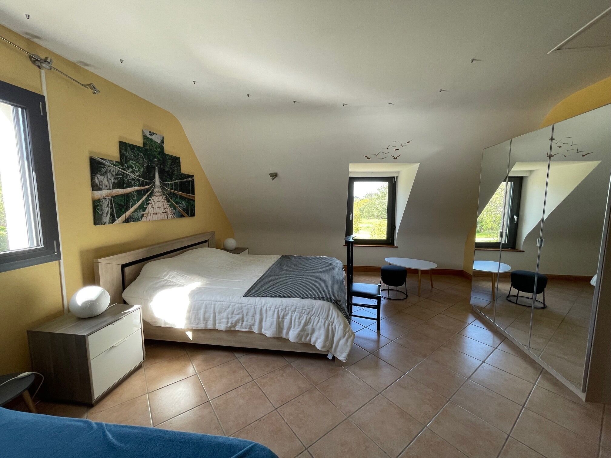 Una camera da letto con un letto, un comodino e una finestra.