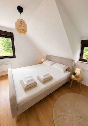 Ein Schlafzimmer mit einem Bett, Nachttischlampen, einem Fenster und einer Deckenleuchte.