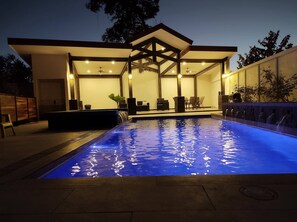 A modern outdoor pool area with a covered seating area and a waterfall feature. - #1 New & Modern 2 bed Suite With Shared Pool (Liberia)