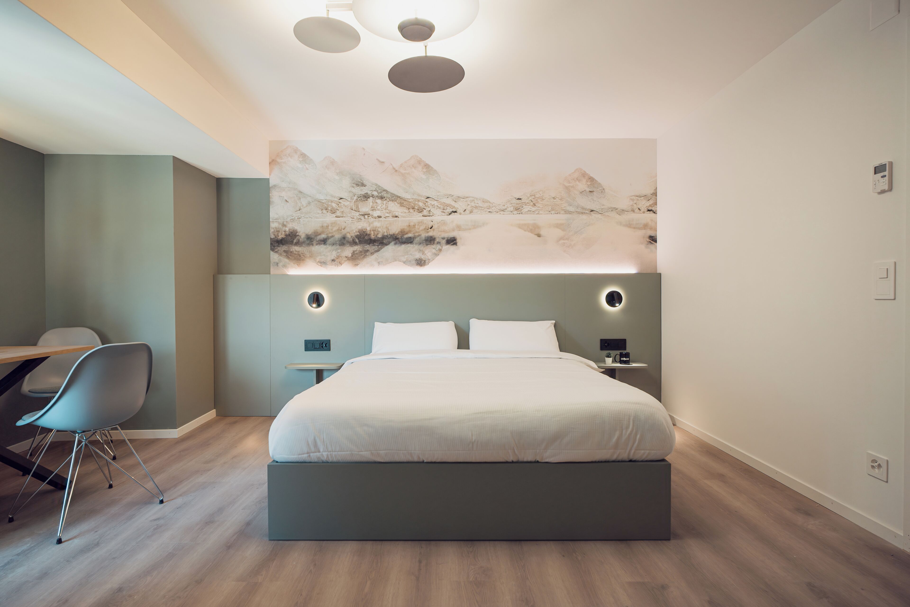 Un dormitorio moderno con una cama grande, un escritorio y una silla.