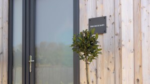 Un mur extérieur en bois, avec une porte et une enseigne indiquant « TWO DUCK BARN ».