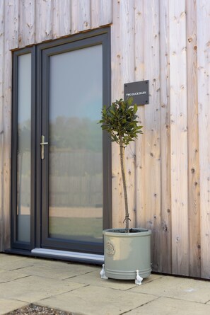 A wooden exterior wall with a door and a sign reading 'TWO DUCK BARN.'