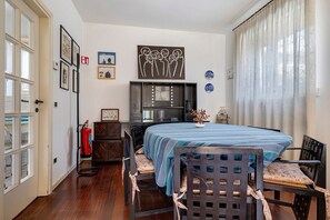 A room with a bed, a desk, a chair, a fire extinguisher, and a window with curtains.