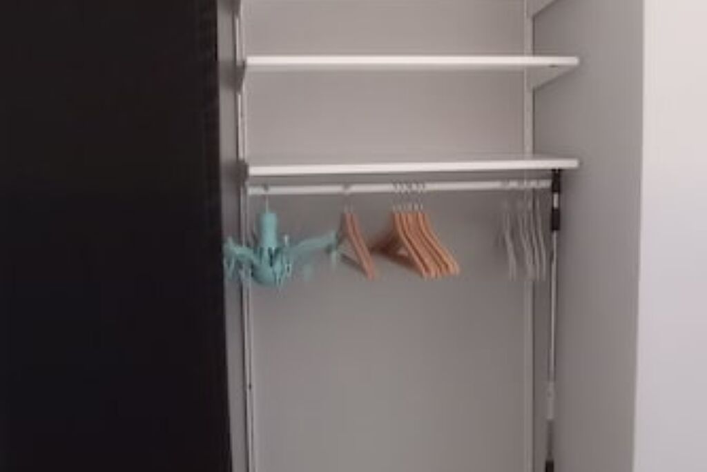 En garderob med hyllor och plats för att hänga kläder.