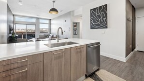 A modern kitchen with a large island, stainless steel appliances, and a view of the city.