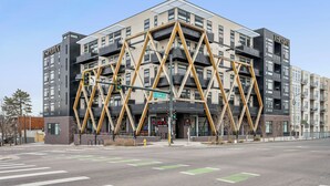 A modern building with a unique geometric facade, labeled "ESPADIN," located at a street corner. - Top Floor | 1BR Corner Loft | LoHi Denver | Dog-Friendly (Denver)
