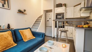 A modern living room with a blue sofa and a dining table set for two. - Quiet room in shared house - Lille (Lille)