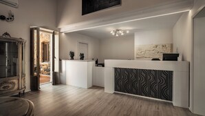 A modern kitchen with a wooden floor, a white countertop, and a patterned backsplash. - Viscuso house (Aci Castello)