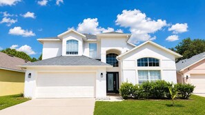 A two-story house with a garage, a front entrance, and a well-maintained lawn. - Theme Park Days & Sunshine Stays (Kissimmee)