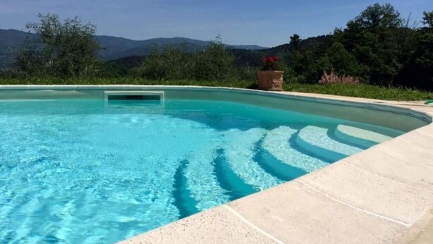 Ein klares Schwimmbecken mit Blick auf Berge im Hintergrund.