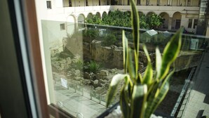 A view of ancient ruins through a window, with a balcony and potted plants in the foreground. - Dimora San Girolamo (Marsala)