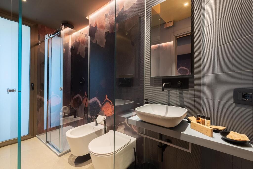 Une salle de bain moderne avec une douche à parois de verre, un grand lavabo et un miroir.