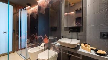 Une salle de bain moderne avec une douche à parois de verre, un grand lavabo et un miroir.