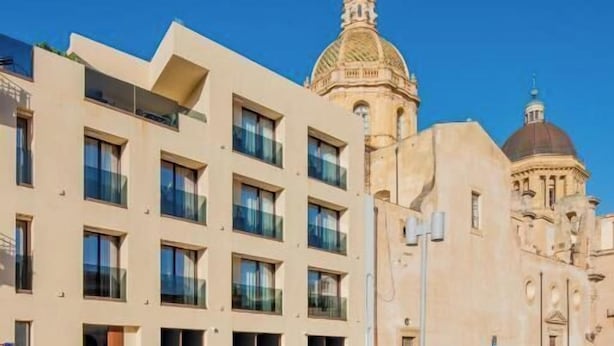 A modern building with a classical dome and a smaller dome in the background. - Dimora San Girolamo (Marsala)
