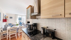 Une cuisine moderne avec un coin repas, comprenant une cuisinière, une machine à café et un grille-pain.