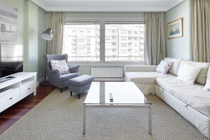 A modern living room with a sofa, armchair, and a coffee table. - Koxka - Basque Stay (San Sebastián)