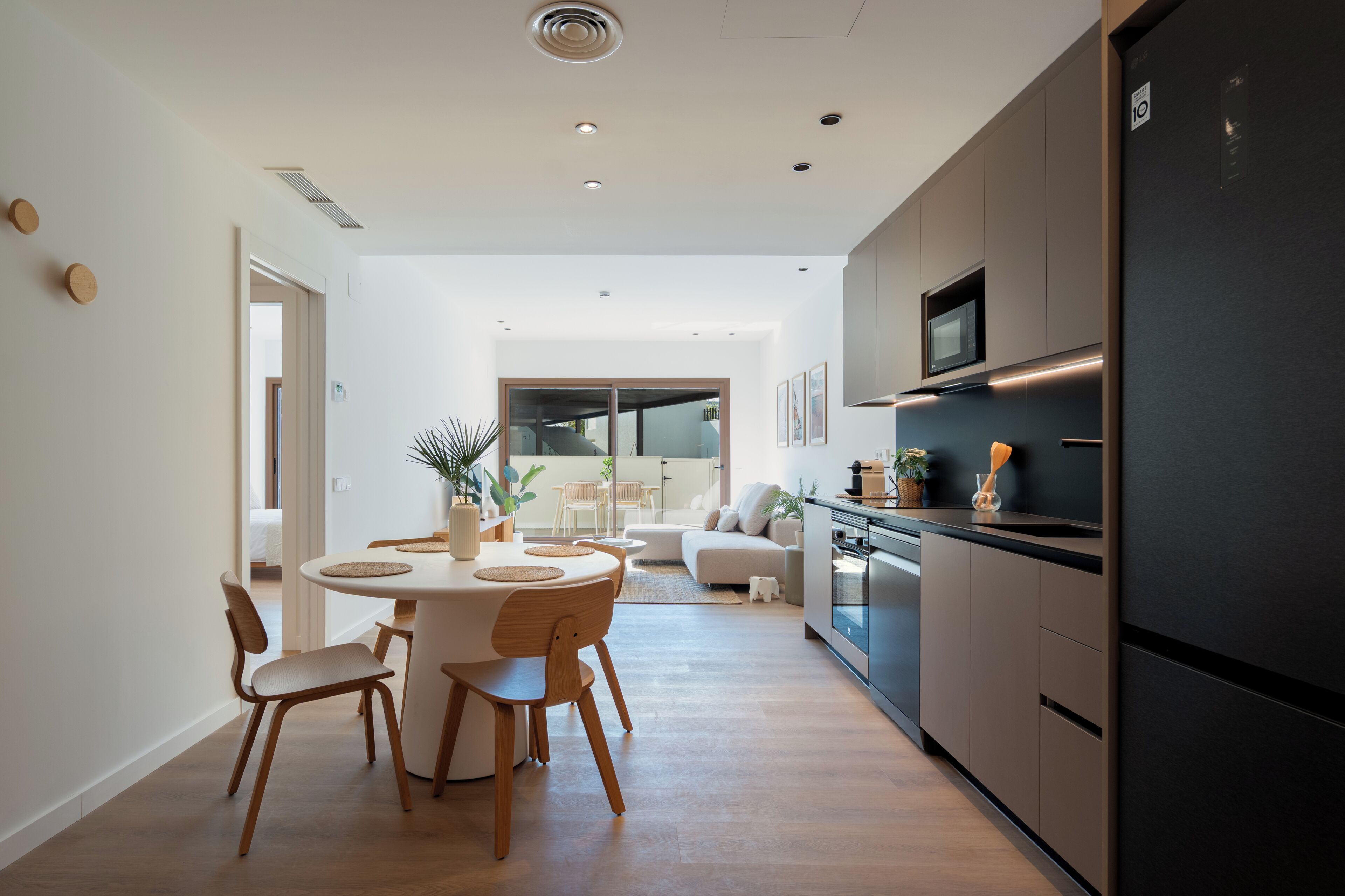 Eine moderne Küche mit Einbauofen, Mikrowelle und einem schwarzen Kühlschrank.