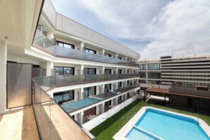 A modern multi-story building with a rooftop pool and a glass balustrade. - Can Milà Apartments  (Sitges)