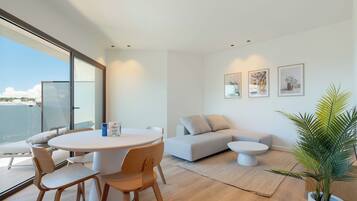 A modern living room with a round table, two sofas, and a potted plant.